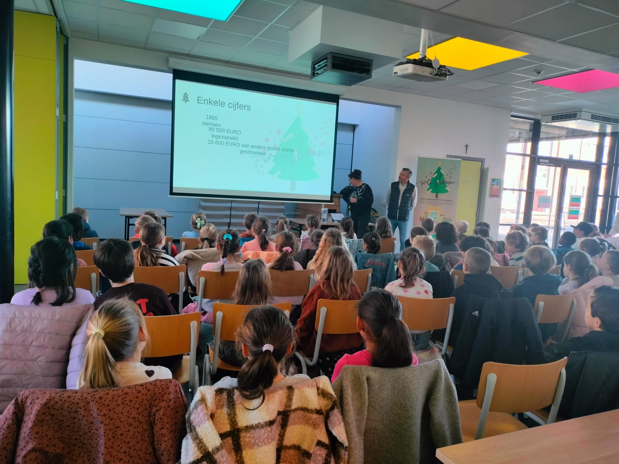 Kinderen luisteren naar een presentatie over de Wensboom