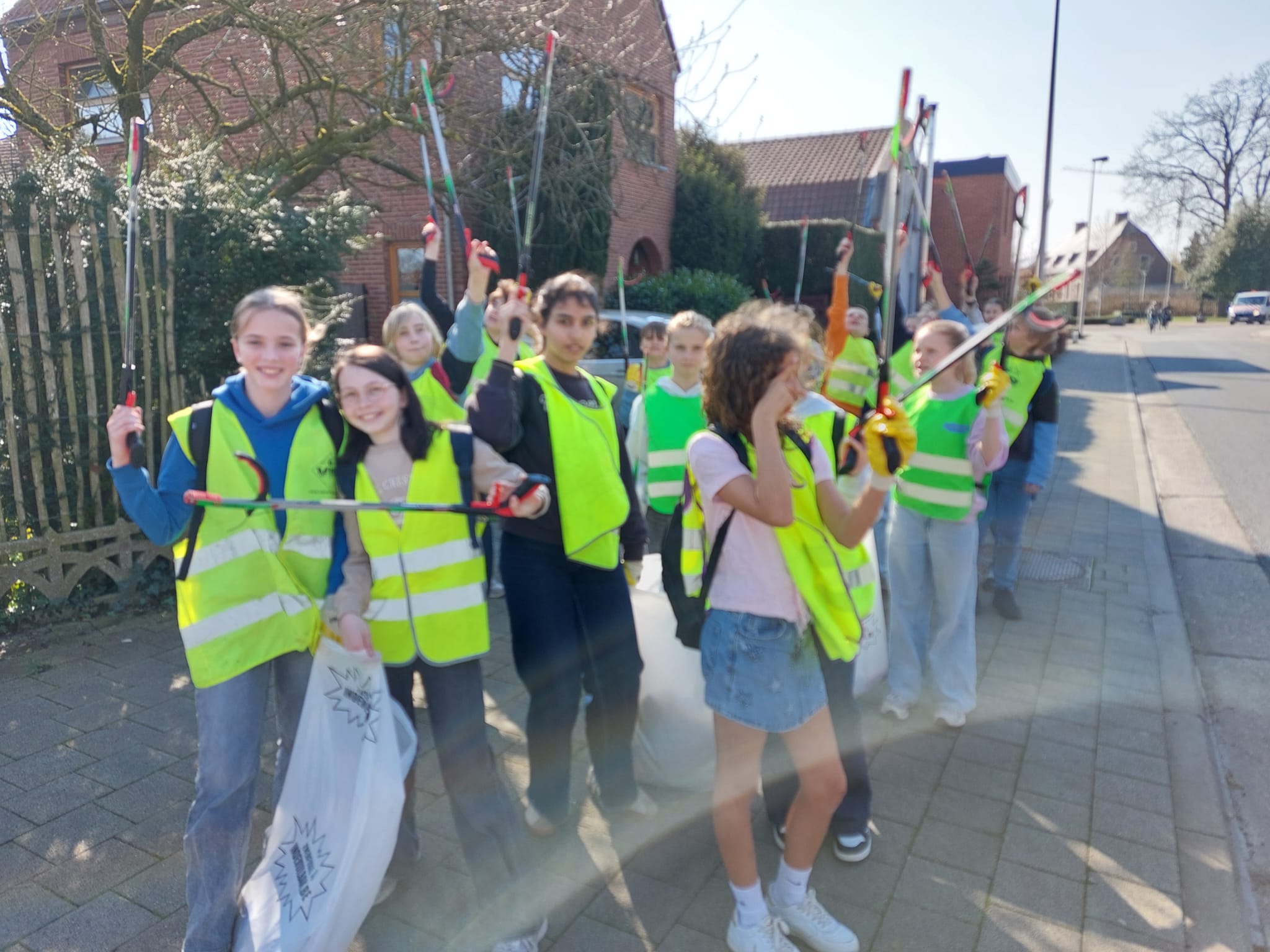 foto van kinderen in fluovestjes die zwerfafval opruimen