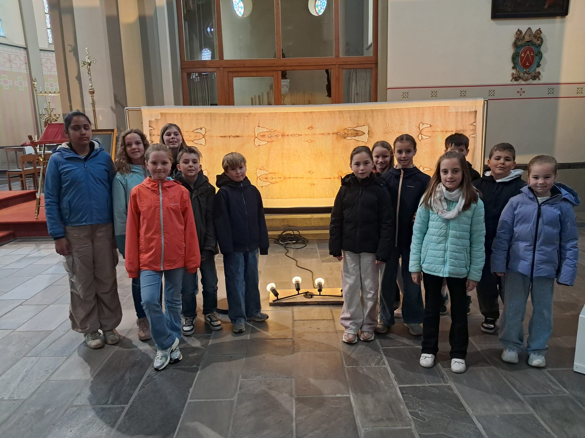 Kinderen staan bij een replica van de lijkwade van Turijn 