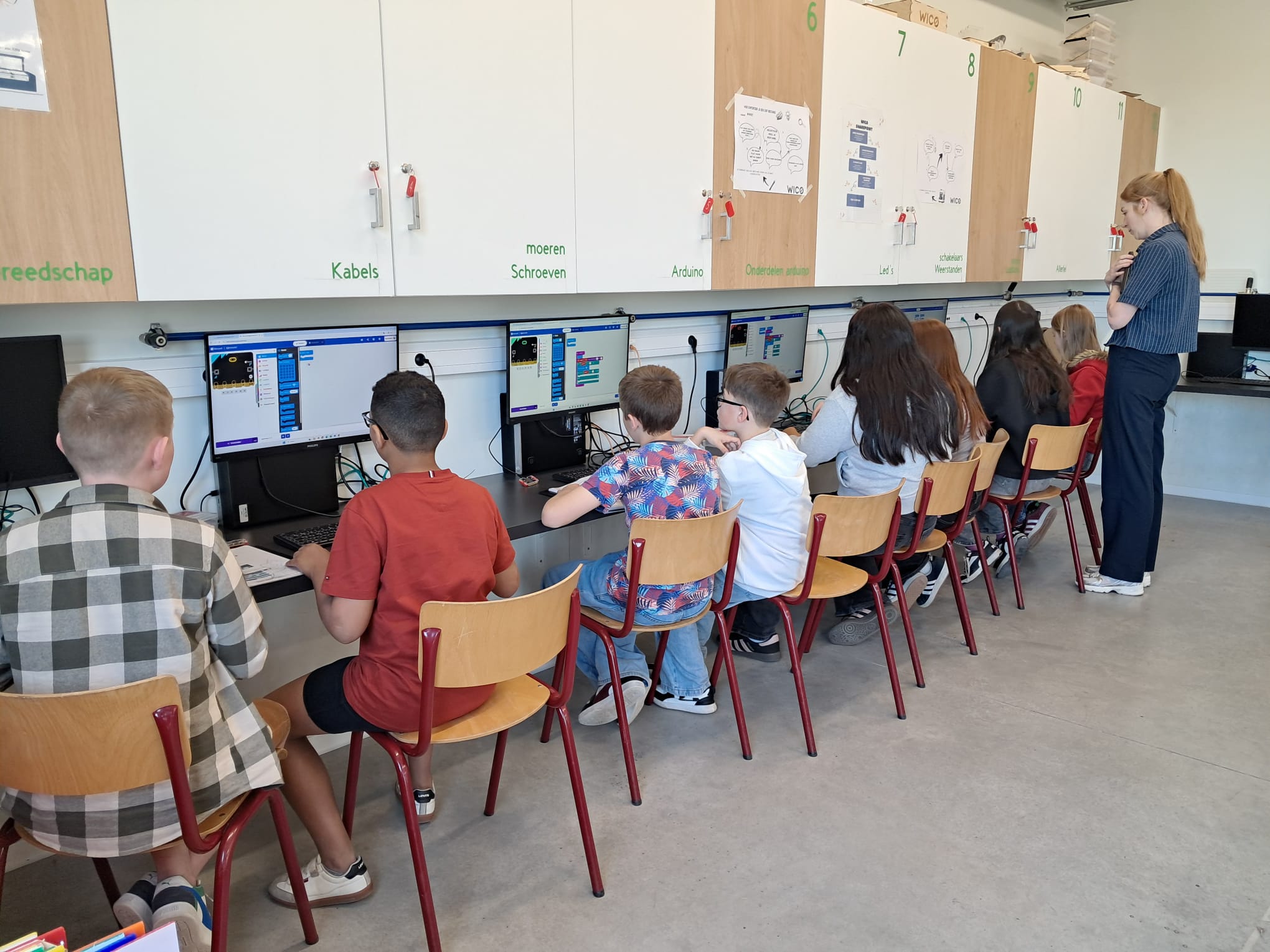 Kinderen zitten aan een computer.