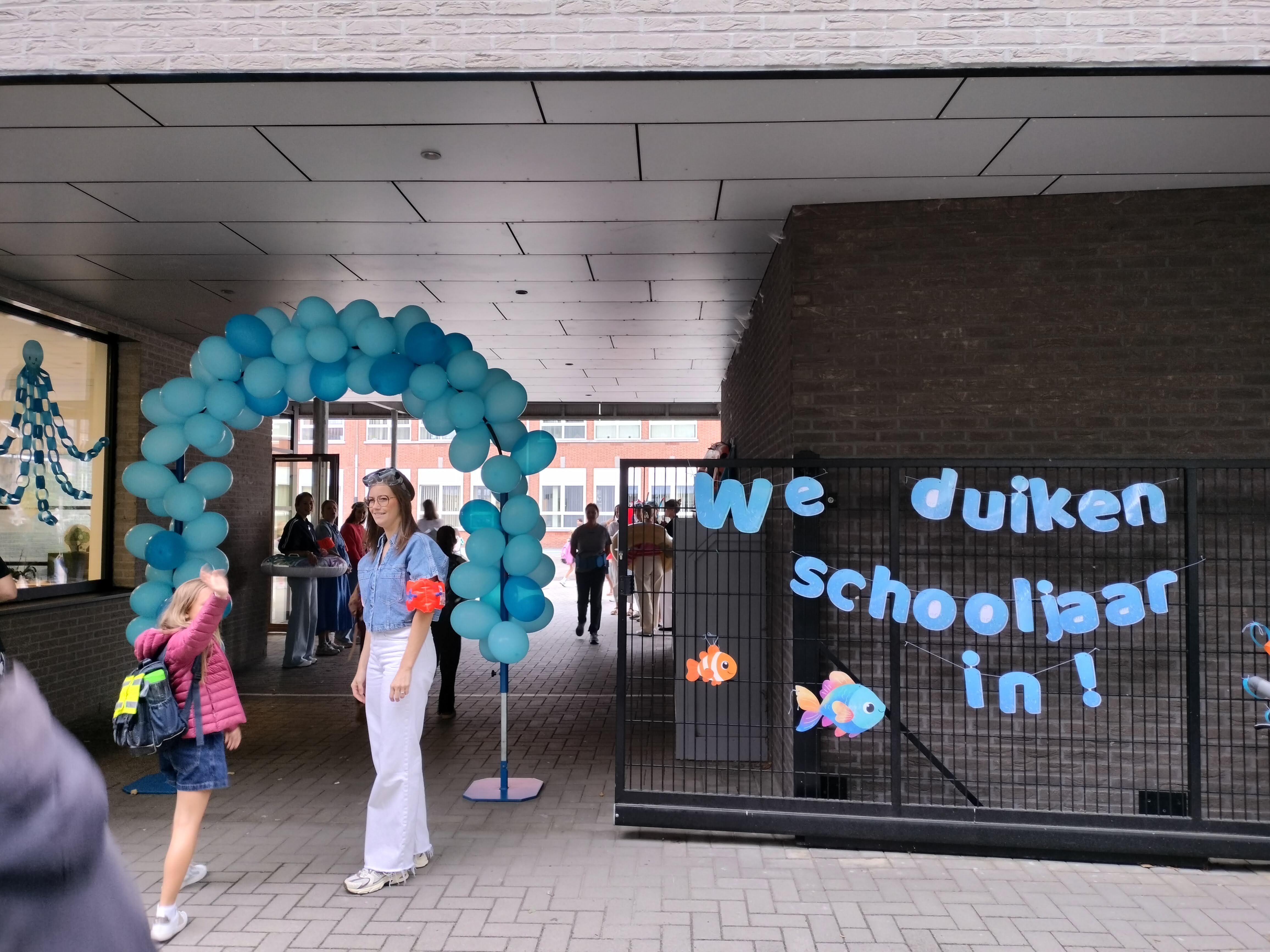 De schoolingang is versierd met ballonnen en 'We duiken het schooljaar in!''