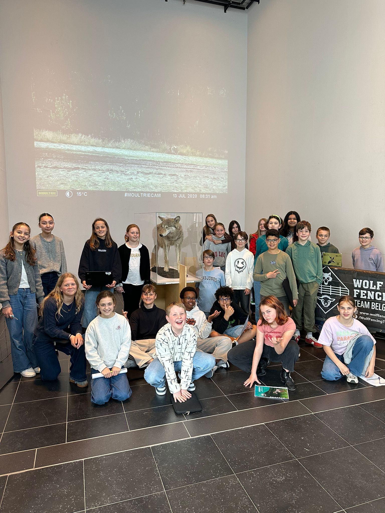 foto van kinderen rond een opgezette wolf
